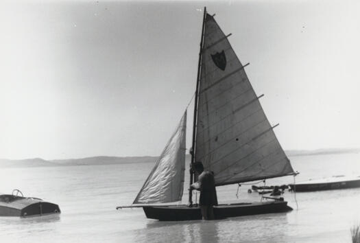 Lake George Sailing Club regatta, showing a yacht and sailor identified as Max Darling. He appears to be checking his sails.