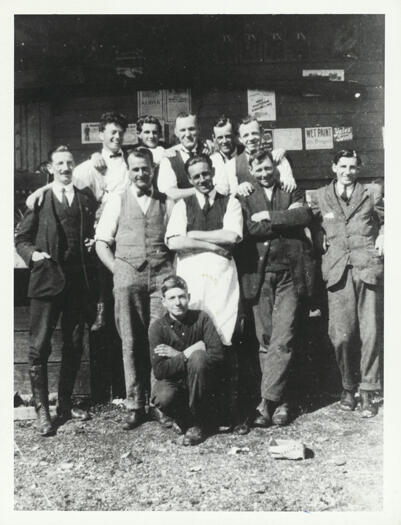 Canberra Co-op Store staff outside the shop. 

Back row: M. Campbell, Eugene De Smet, J. Gallagher, Dave Pegram, Keith Carnall

Front row: E. Paynting, Jack Esmond (manager), Bob Shannon, Phil Corkhill, Norman Reid

Front: Jack Cotterill