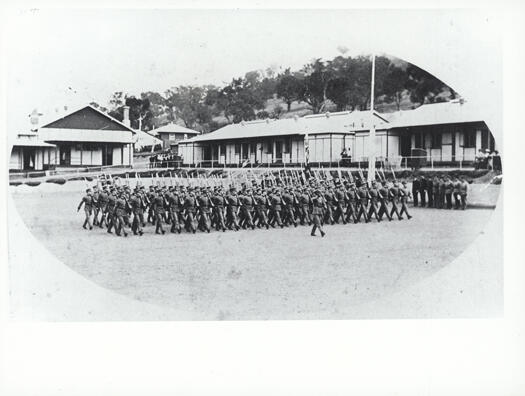 The parade ground of the Royal Military College, Duntroon. The photo shows over 80 Staff Cadets marching past a saluting point. 