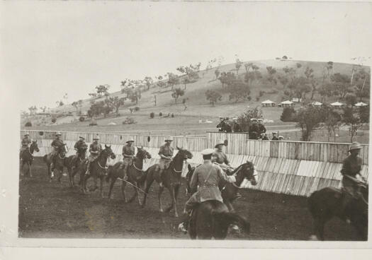 Equestrian training at Duntroon. The photo shows 8 mounted cadets and the Riding Instructor (H. Shappere) with senior staff observing from a viewing platform. The last RMC Gymkhana was held in August 1940. Cavalry training was eliminated from the RMC curriculum in 1941 due to the developments in mechanised warfare.