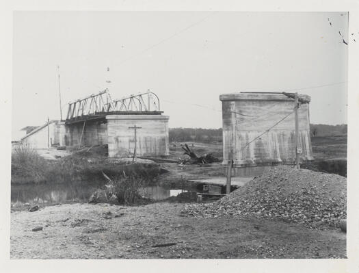 Shows the incomplete foundations of an unknown bridge after a flood.