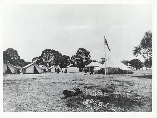 Colonel Miller's tent at the Canberra Day ceremony showing a flapole and flag in the foreground.