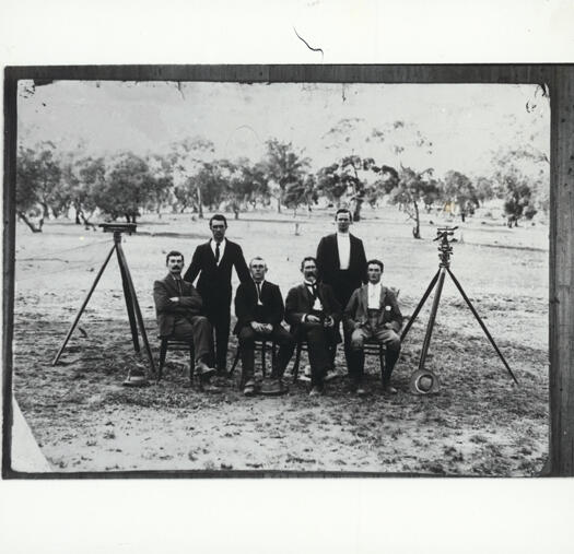 Group of six unnamed early Canberra surveyors at their camp with two theodolites