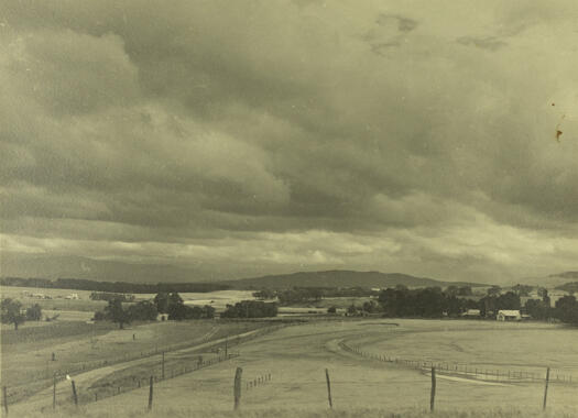 Kaye's Dairy on the right and Corkhill's Dairy on the left. Government House can be seen in the distance on the left and Black Mountain on the right. The Molonglo River flows through the middle of the photo.
