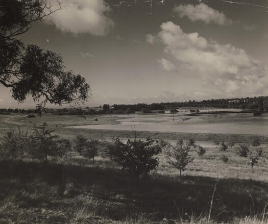 Molonglo River in flood looking west with Parliament House on the left and Duntroon on the right.