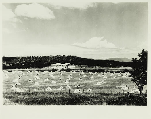 Looking across haystacks in the paddocks to Parliament House