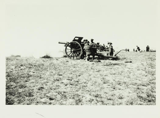 Artillery guns firing the salute at the opening of Parliament House, showing a close look at the nearest gun crew.