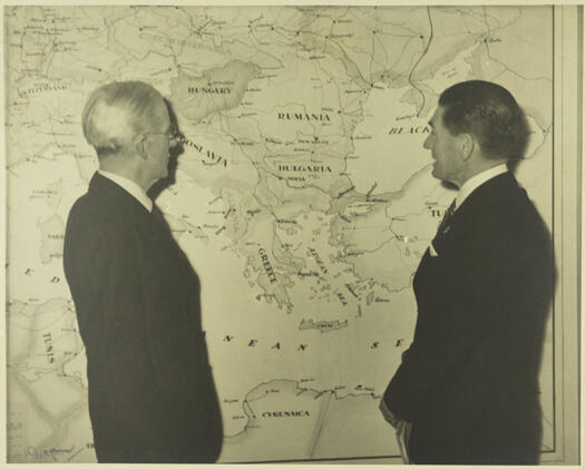 Sir Henry Gullett and Mr Street in Parliament House, September 1939, looking at a map of Europe showing the progress of the German armies in Poland.