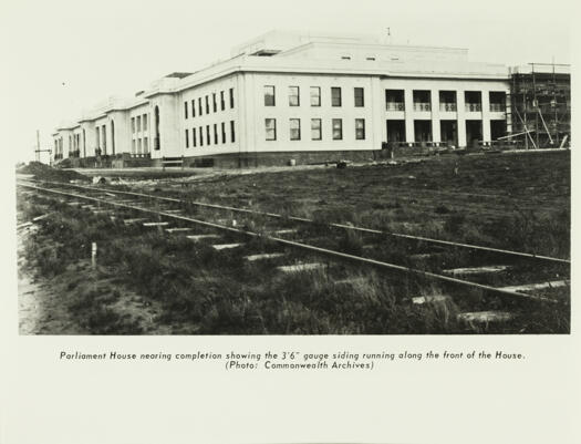The almost completed Parliament House under construction with the 3 foot 6 inch gauge railway line running in front of the building.