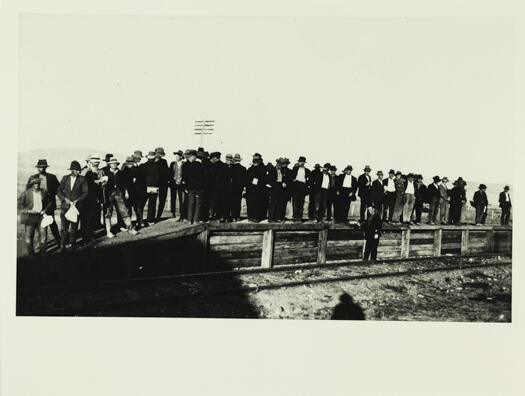 A crowd of people standing on the temporary railway platform in Civic.