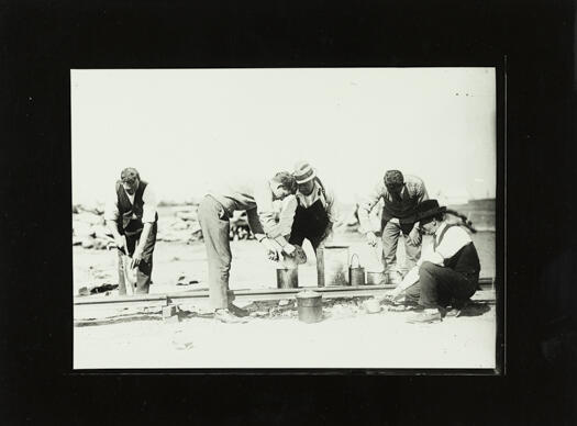 Railway workers who appear to have just boiled the billy and are getting ready for a meal break.