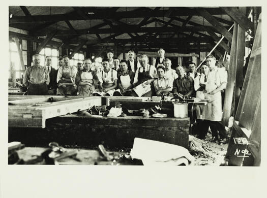 A group photo of 19 men at the joinery shop, Kingston
