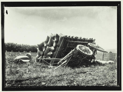 Laden dray lying on its side with a load of full bags.