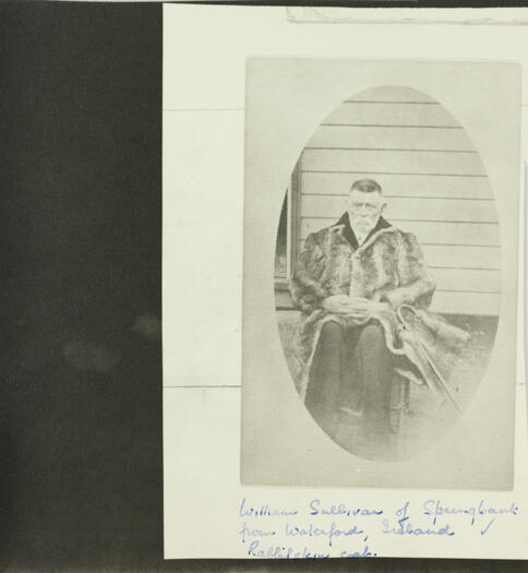 William Sullivan of Springbank sitting on a chair warring a rabbit skin coat. 