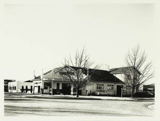 A front view of Esmonds Motors Garage with Mildren's Garage to the extreme right and beyond that, a house.