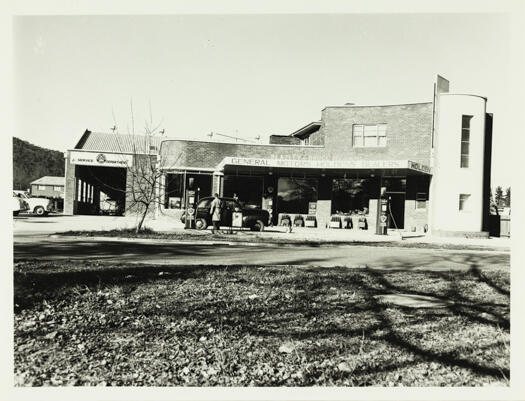 Front view of the Beazley and Bruce garage in Braddon showing petrol bowsers and an early model Holden car.