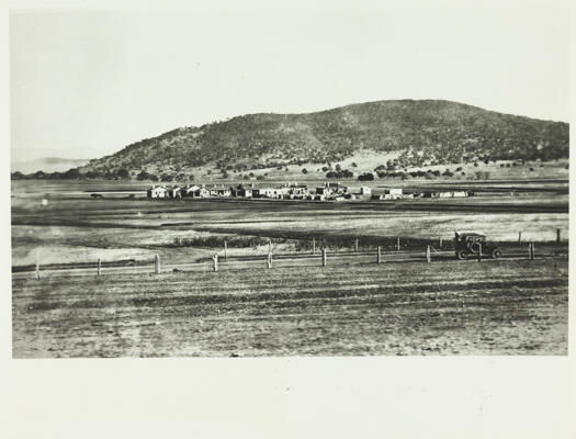 Photo shows a small cluster of buildings in Reid with Mt. Majura in the background.