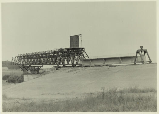 Kings Avenue Bridge under construction showing a mobile hydraulic jack moving a pre-stressed concrete beam into the steel gantry