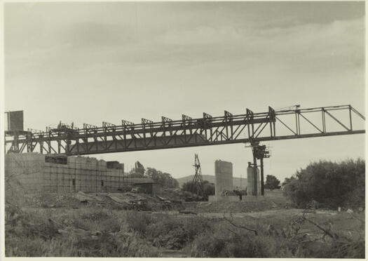 Kings Avenue Bridge under construction. A view looking west showing a pre-stressed concrete beam inside the steel gantry ready for lowering on to the piers.