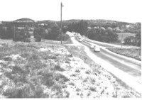 Shows southbound traffic approaching the old Commonwealth Avenue Bridge over the Molonglo River.