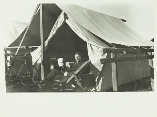 Bachelor tents, man sitting with bicycle