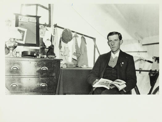 Acton - bachelor tents, interior, man reading a book