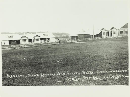 Department of Home Affairs, Survey department, Post Office and  Commonwealth Bank at Acton. Shows a front view of the building with a wooden rail fence in front.