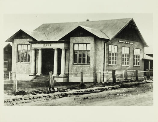 A front and side view of the Commonwealth Bank, Acton. Three steps lead to the entrance, two pillars on either side of the steps.