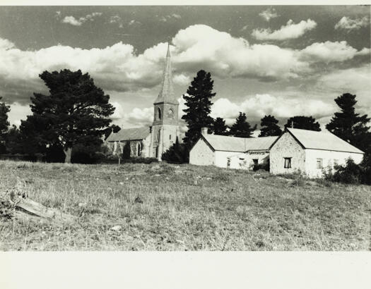 A view from a distance of St John's Church with the old school building