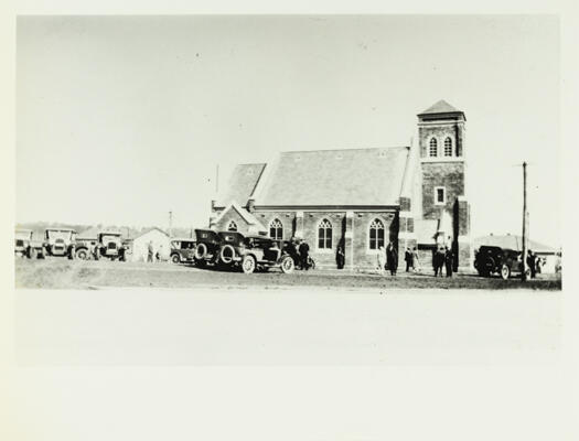 A side view of the Methodist Church, Coranderrk Street, Reid. Photo shows ten cars parked by the side of the church with people standing around.