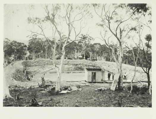 Construction of Red Hill reservoir showing a hole in the round with a roofless shed.