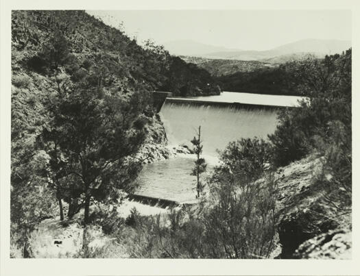 Cotter Dam - spillway. Shows completed dam wall with water flowing over the wall.