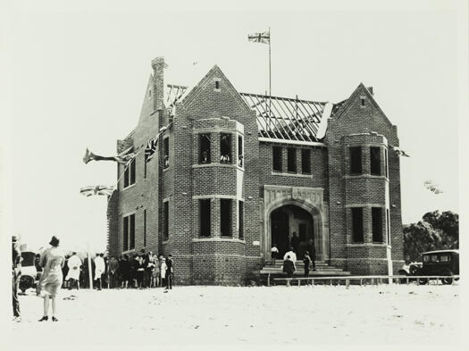 Laying the foundation stone of the Canberra Grammar School in front of a crowd of onlookers.