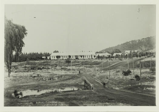 Shows the Duntroon School on a rise with three houses close by.