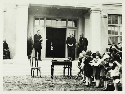 Ainslie Primary School opening by the Prime Minister, the Right Honourable Stanley Bruce in September 1927. School children are standing in front of the steps.