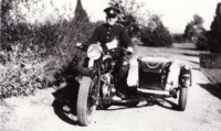 Police Commissioner, Ted Richards riding a motor cycle with sidecar.