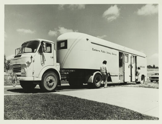 Mobile library at a school showing a couple of people entering the vehicle.