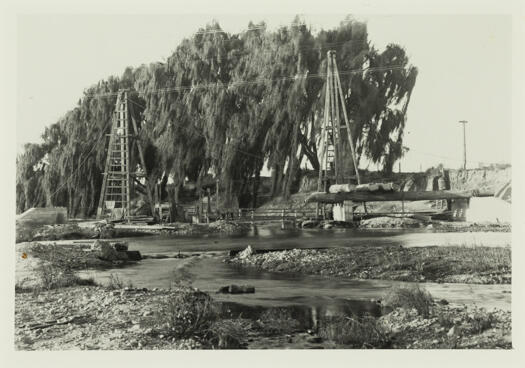 Shows the start of the construction of the suspension bridge over the Queanbeyan River