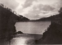 A view of the Cotter Dam with water flowing over the wall
