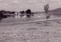 Yacht Clubhouse from across Lotus Bay, Yarralumla. Several sail boats are anchored in the lake.