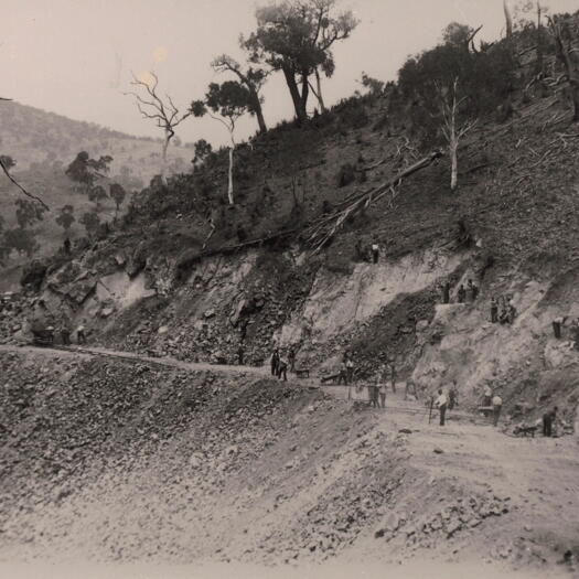 Road construction showing a mountain track leading up from the Cotter valley.