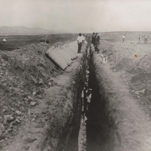 Trench construction from Parliament House to the Government Printing Office on Wentworth Avenue, Kingston. The trench is deeper than the height of two men standing.