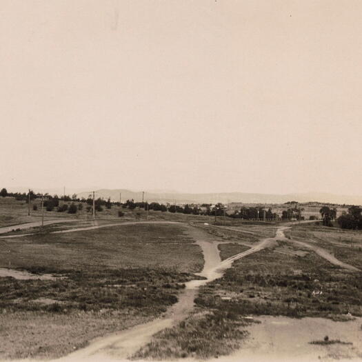 Parliament House is visible on the distant right and Scotts Crossing can be seen through trees on the right.