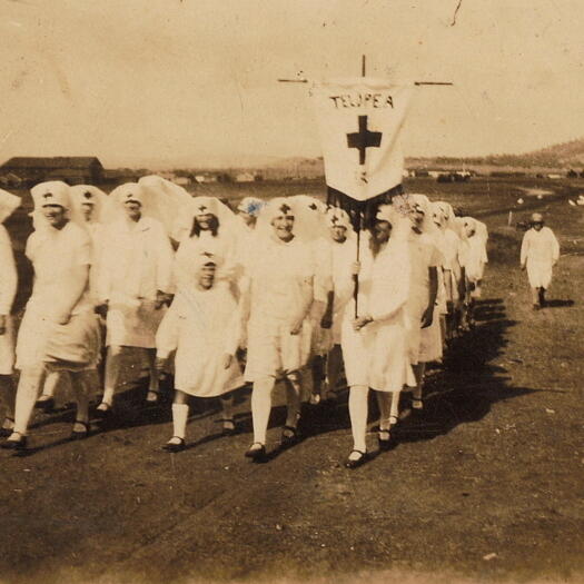 Rose Hunt's family photos showing a group of girls, dressed as nurses, marching with a banner with Telopea written on it. A building, similar to the Power House, is in the background.