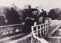 Tractor hauling materials across Cotter Bridge