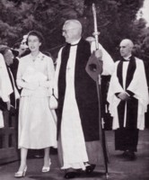 Queen Elizabeth II walking in the grounds of St. John's Anglican Church with an Anglican minister.