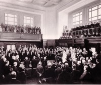 Opening of Parliament House in the Senate chamber showing the Duke and Duchess of York and parliamentarians standing. Members of the public in the galleries are also standing.