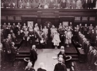 Opening of Parliament House in the Senate Chamber, taken from the end gallery. The Duke and Duchess are standing as are the official guests and parliamentarians.