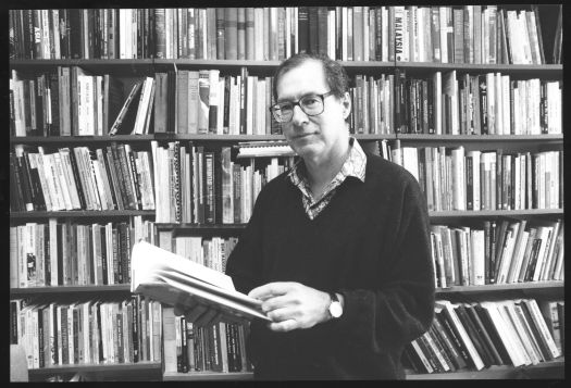 Unidentified ANU academic holding a book in a libary