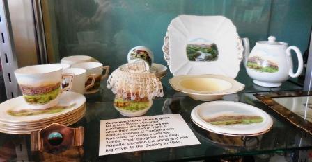 Tea set depicting scenes of Canberra including Parliament House, the Speaker's chair in the House, "Yarralumla", the Cotter Dam. There are 6 teacups, 5 saucers, 5 small plates, 1 cake plate, 1 teapot and stand, 1 milk jug.
